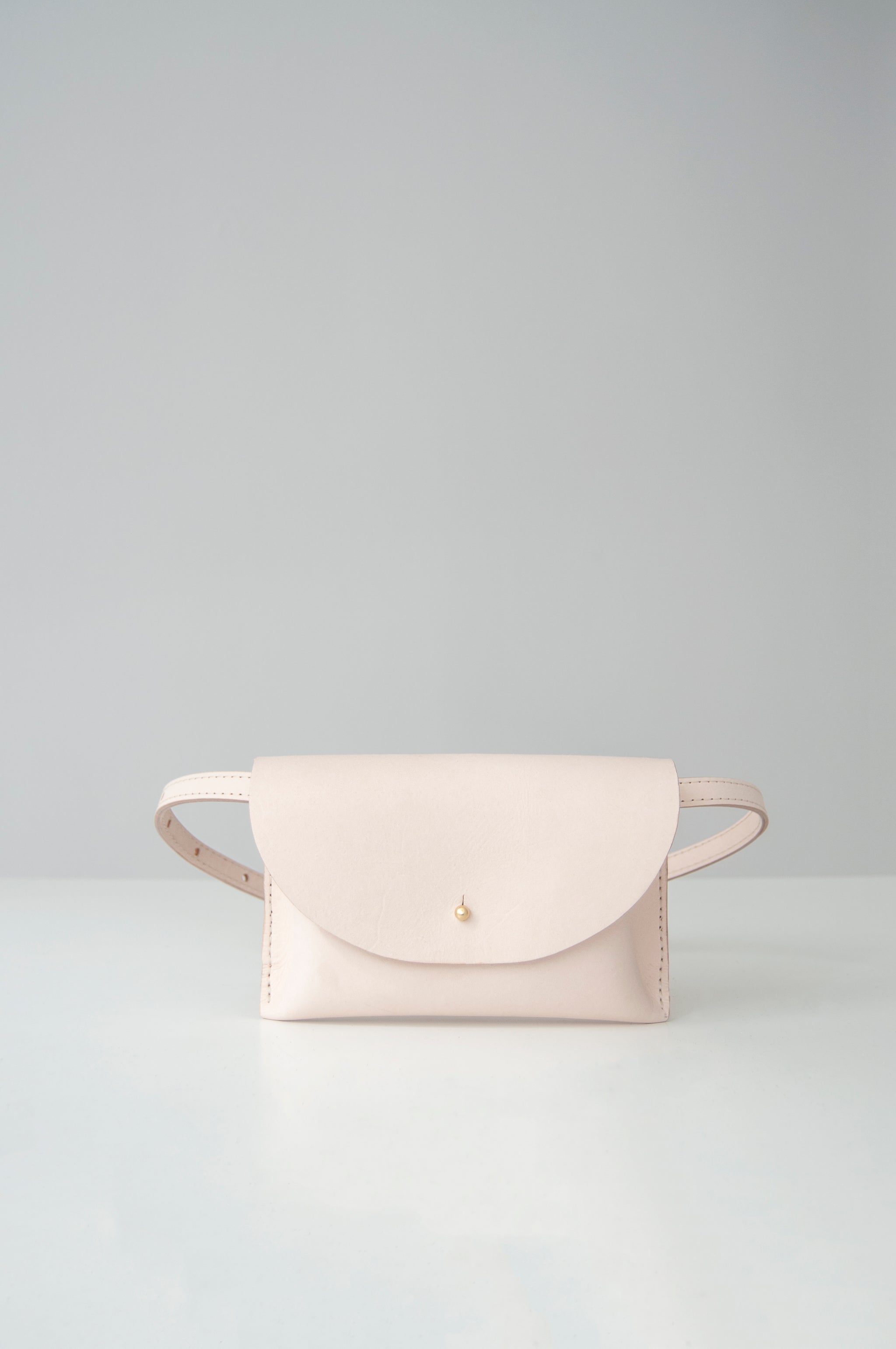 Front view of the Glare Sling in beige veg tan leather