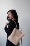 Female model with the Small Ray Backpack in Horween beige dearborn leather